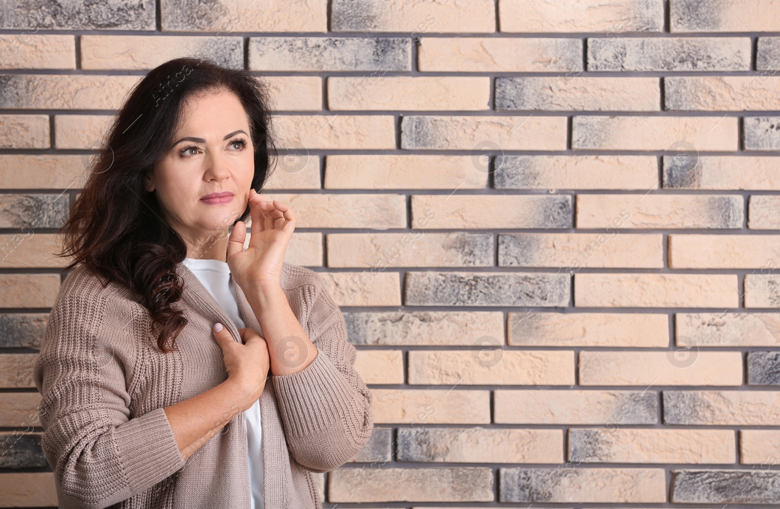 Photo of Portrait of beautiful older woman against brick wall with space for text