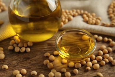 Photo of Composition with soybean oil on wooden table, closeup