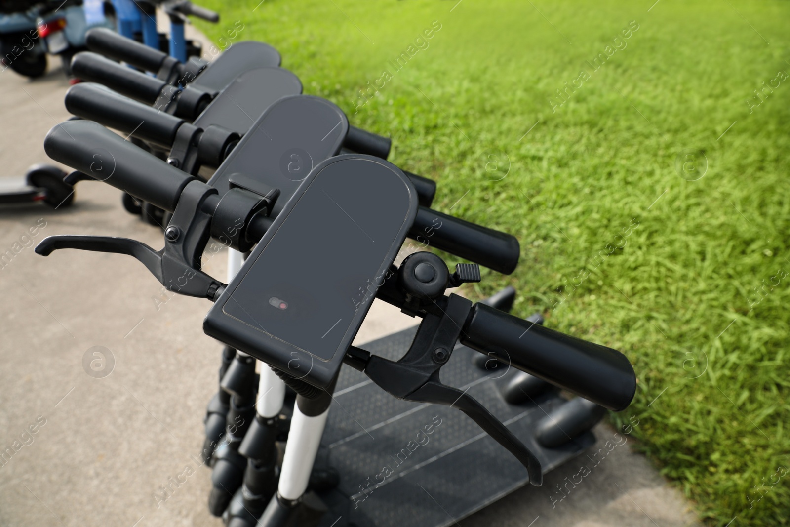 Photo of Row of electric scooters outdoors, closeup. Rental service