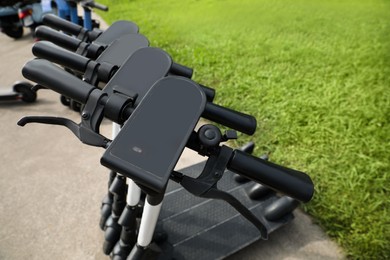 Photo of Row of electric scooters outdoors, closeup. Rental service