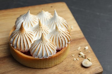 Photo of Tartlet with meringue on black table, closeup and space for text. Delicious dessert