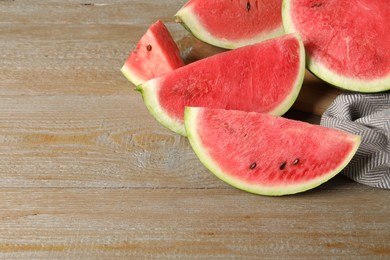 Photo of Delicious fresh watermelon slices on wooden table. Space for text