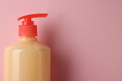 Photo of Bottle of liquid soap on pink background. Space for text