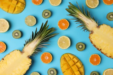 Different ripe fruits on light blue background, flat lay