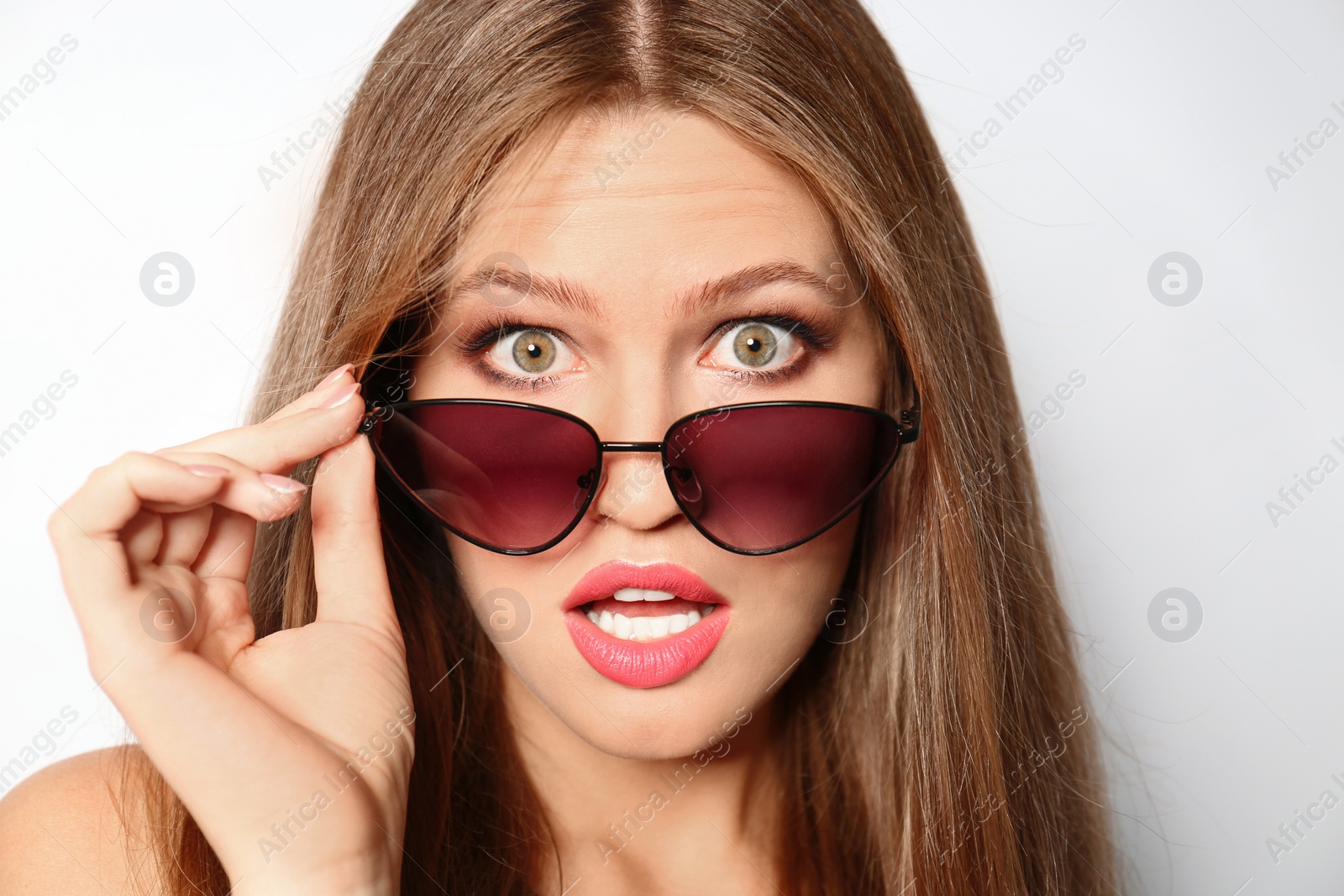 Photo of Young woman wearing stylish sunglasses on light background