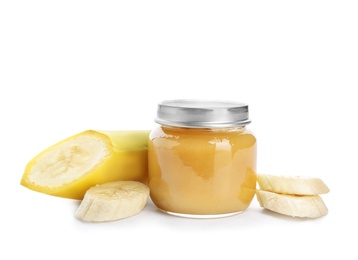 Jar with healthy baby food and cut banana on white background