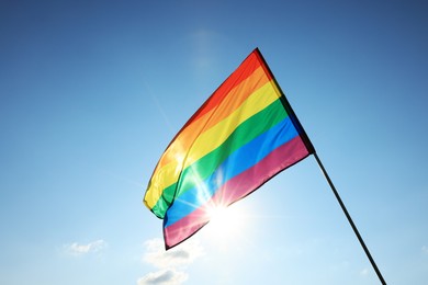 Photo of Bright LGBT flag fluttering against blue sky, space for text. Lesbian concept