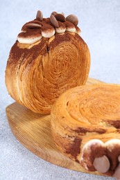 Supreme croissants with chocolate chips and cream on grey table, closeup. Tasty puff pastry