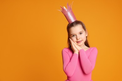 Cute girl in pink crown on yellow background, space for text. Little princess