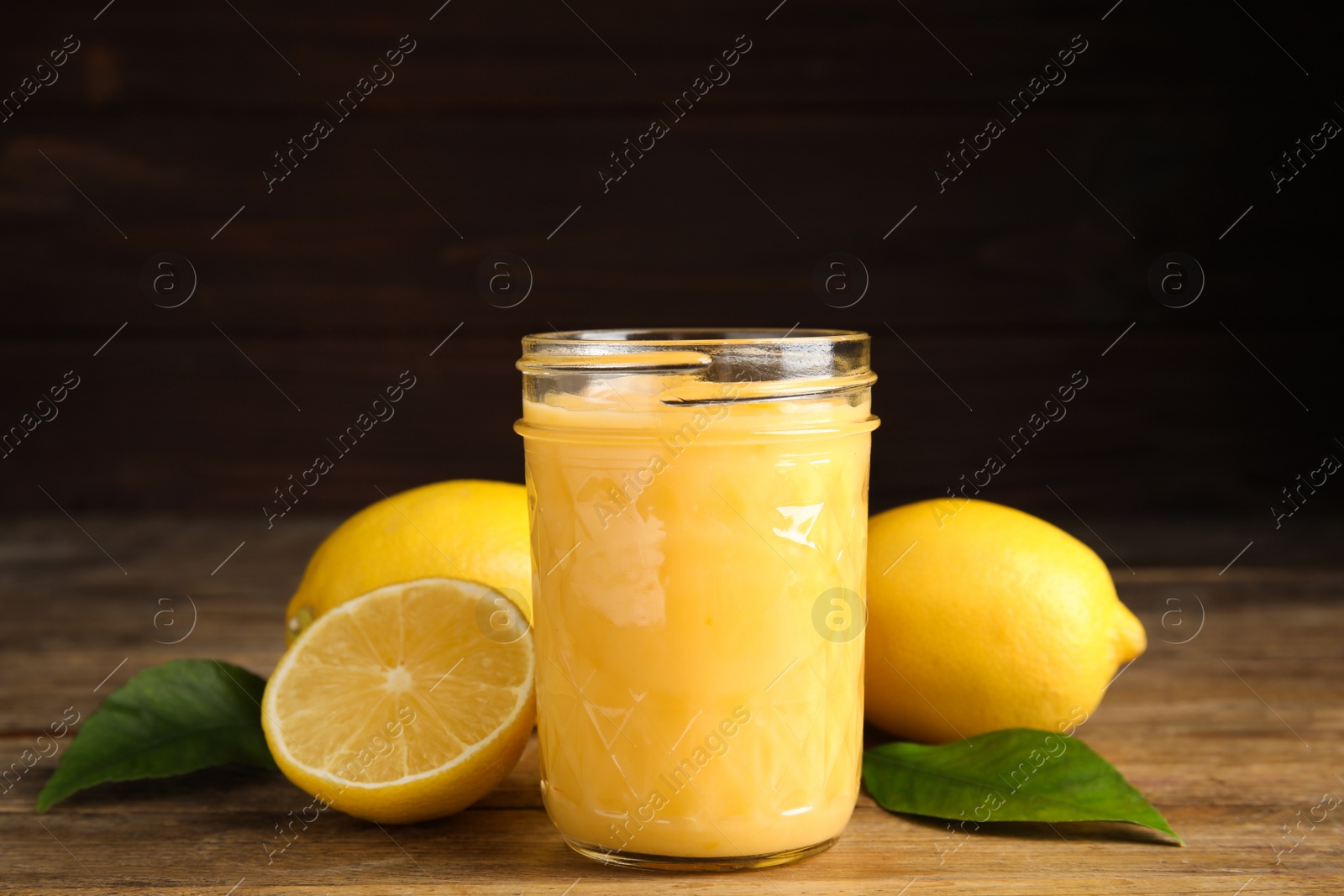 Photo of Delicious lemon curd and fresh fruits on wooden table