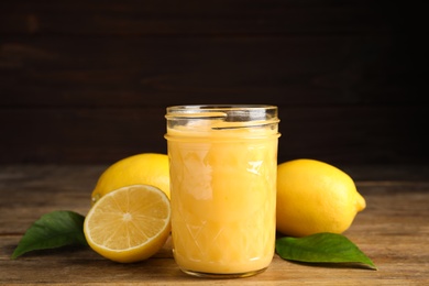 Delicious lemon curd and fresh fruits on wooden table