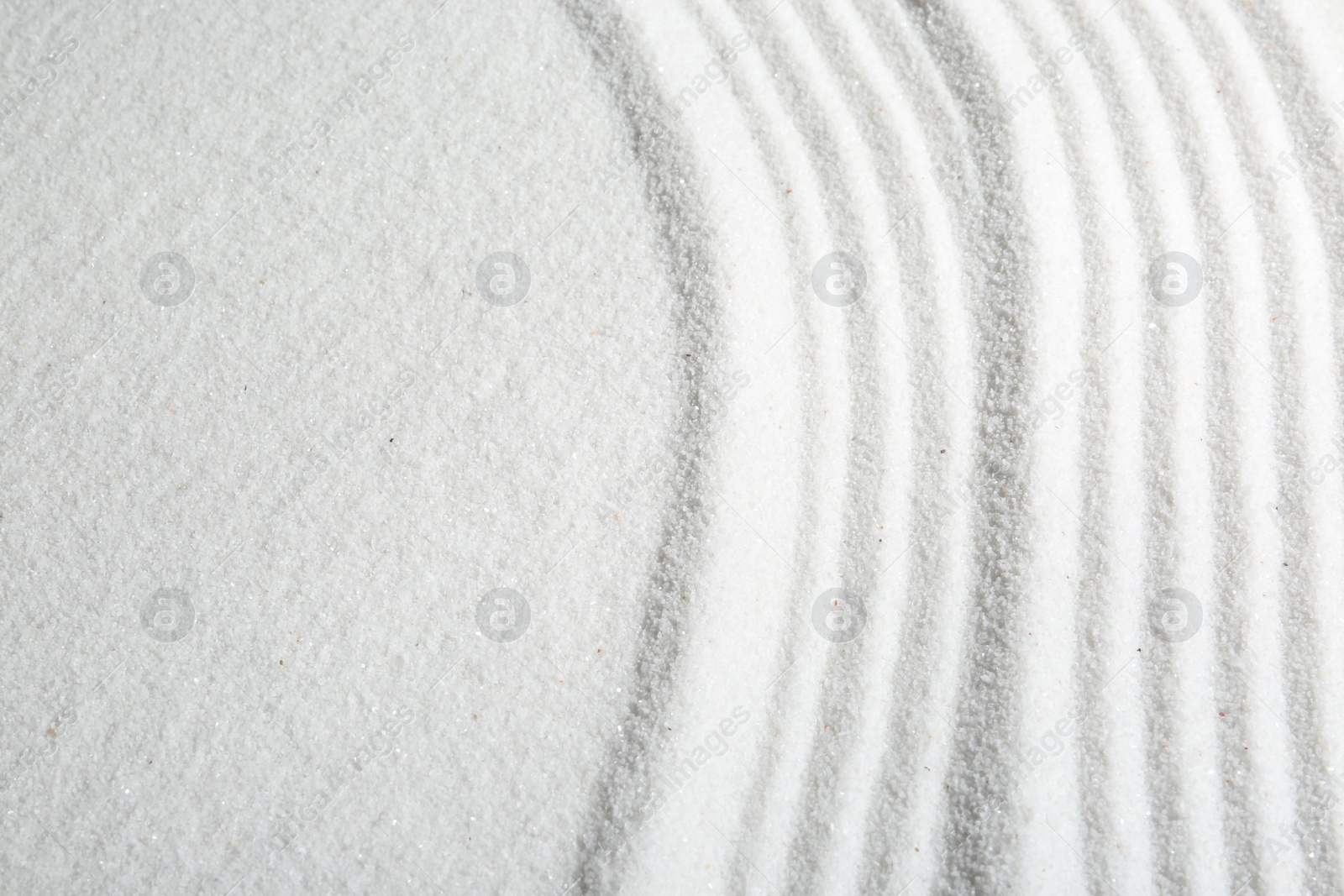 Photo of Zen rock garden. Wave pattern on white sand