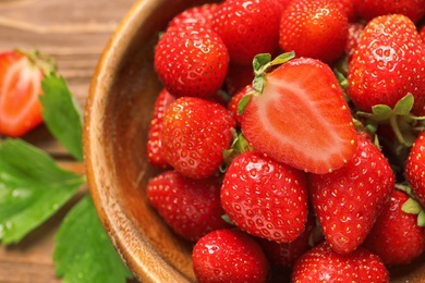 Photo of Bowl with ripe strawberries on table, closeup