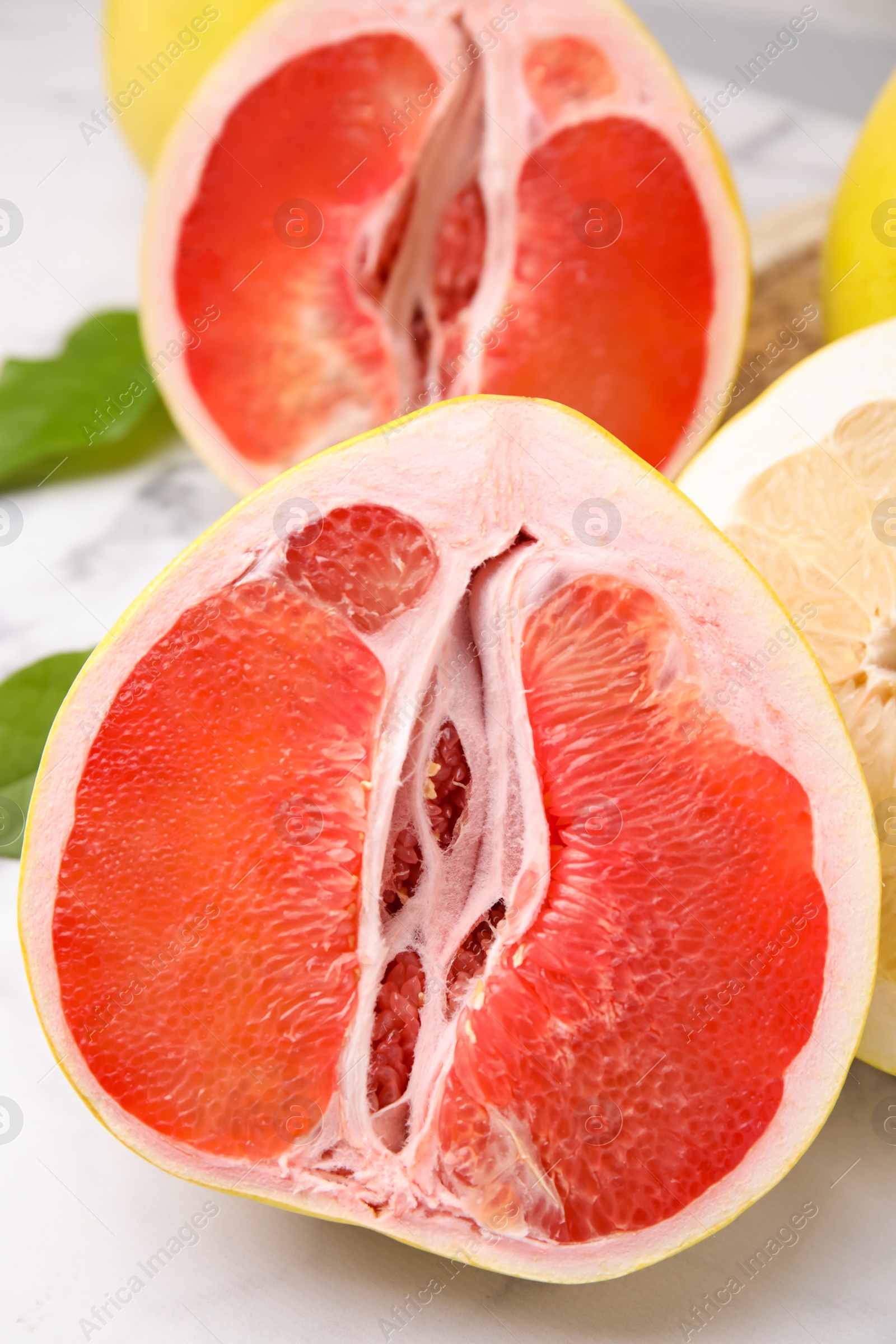 Photo of Different tasty pomelo fruits on white table, closeup