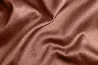 Textured rose gold fabric as background, closeup view