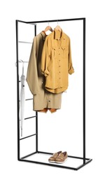 Photo of Stylish rack with clothes and shoes on white background