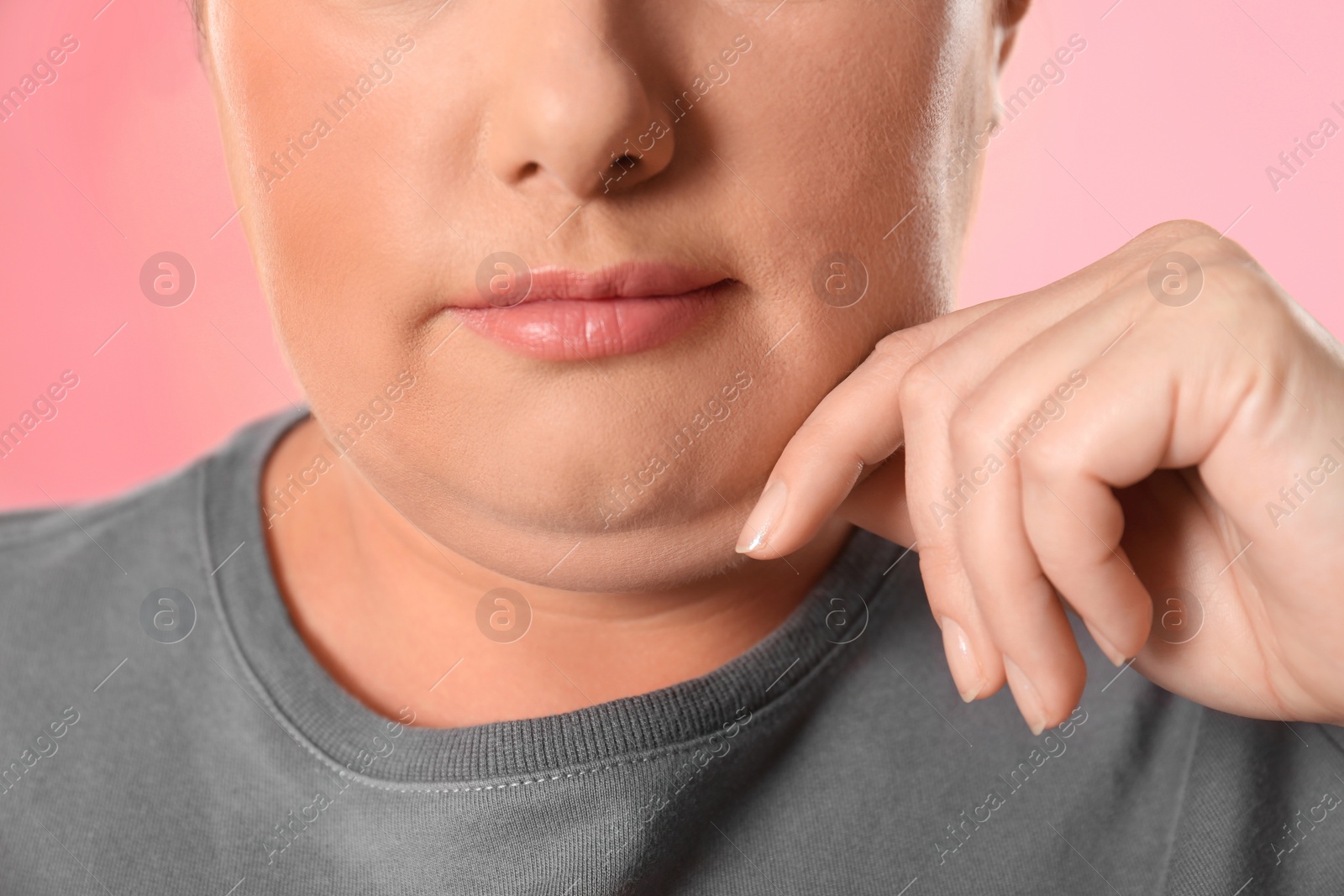 Photo of Woman with double chin on pink background, closeup