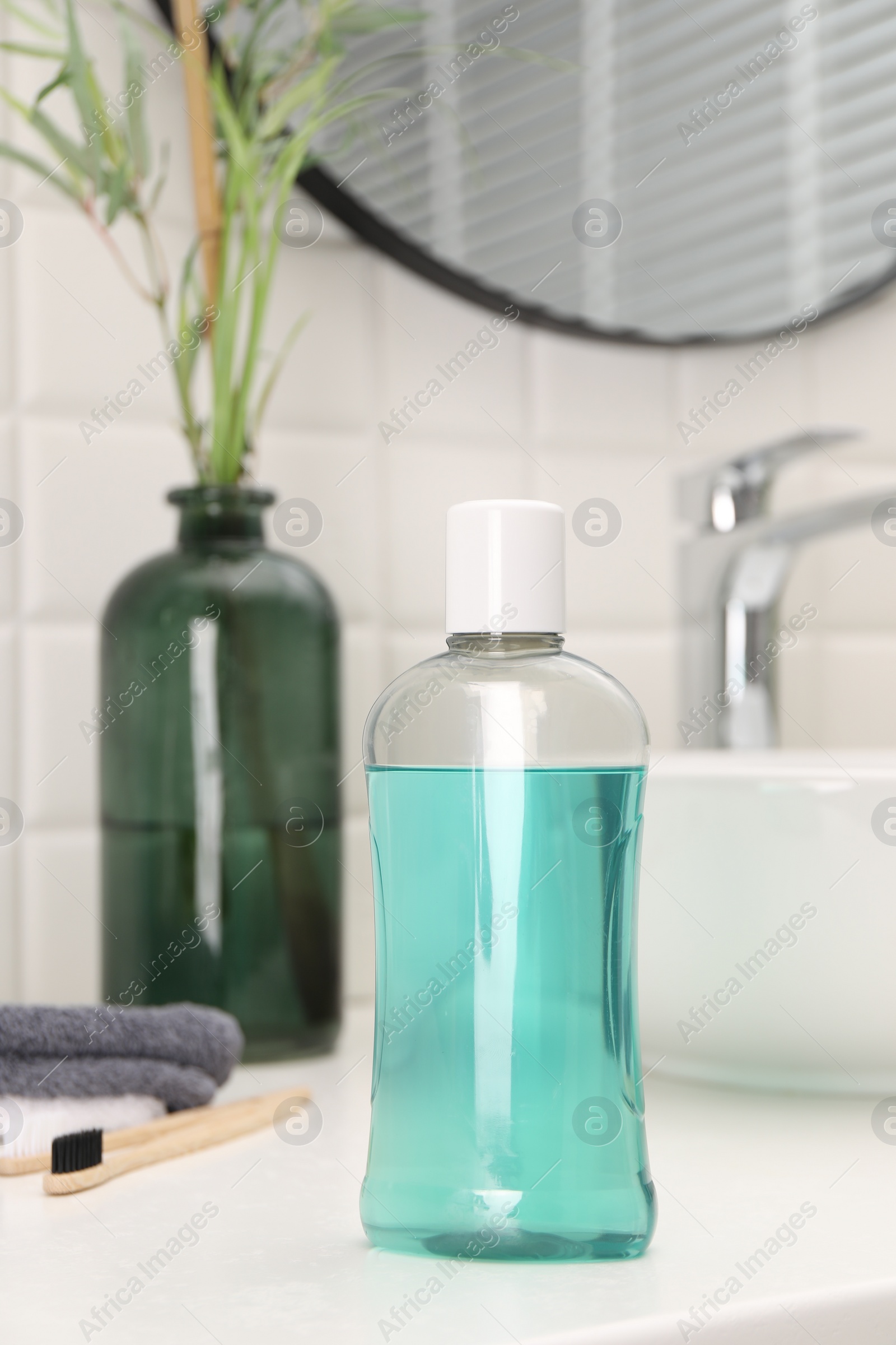 Photo of Bottle of mouthwash on white table in bathroom