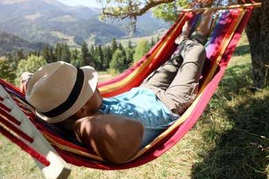 Man resting in hammock outdoors on sunny day