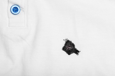 Photo of Stain of black ink on white shirt, top view. Space for text