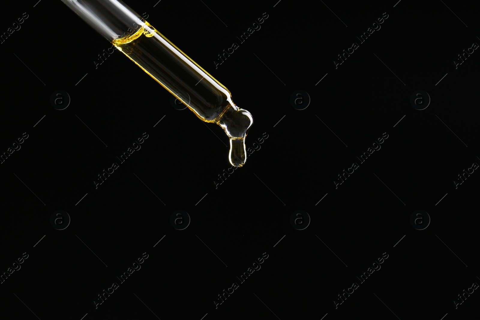 Photo of Dripping tincture from pipette on black background, closeup. Space for text