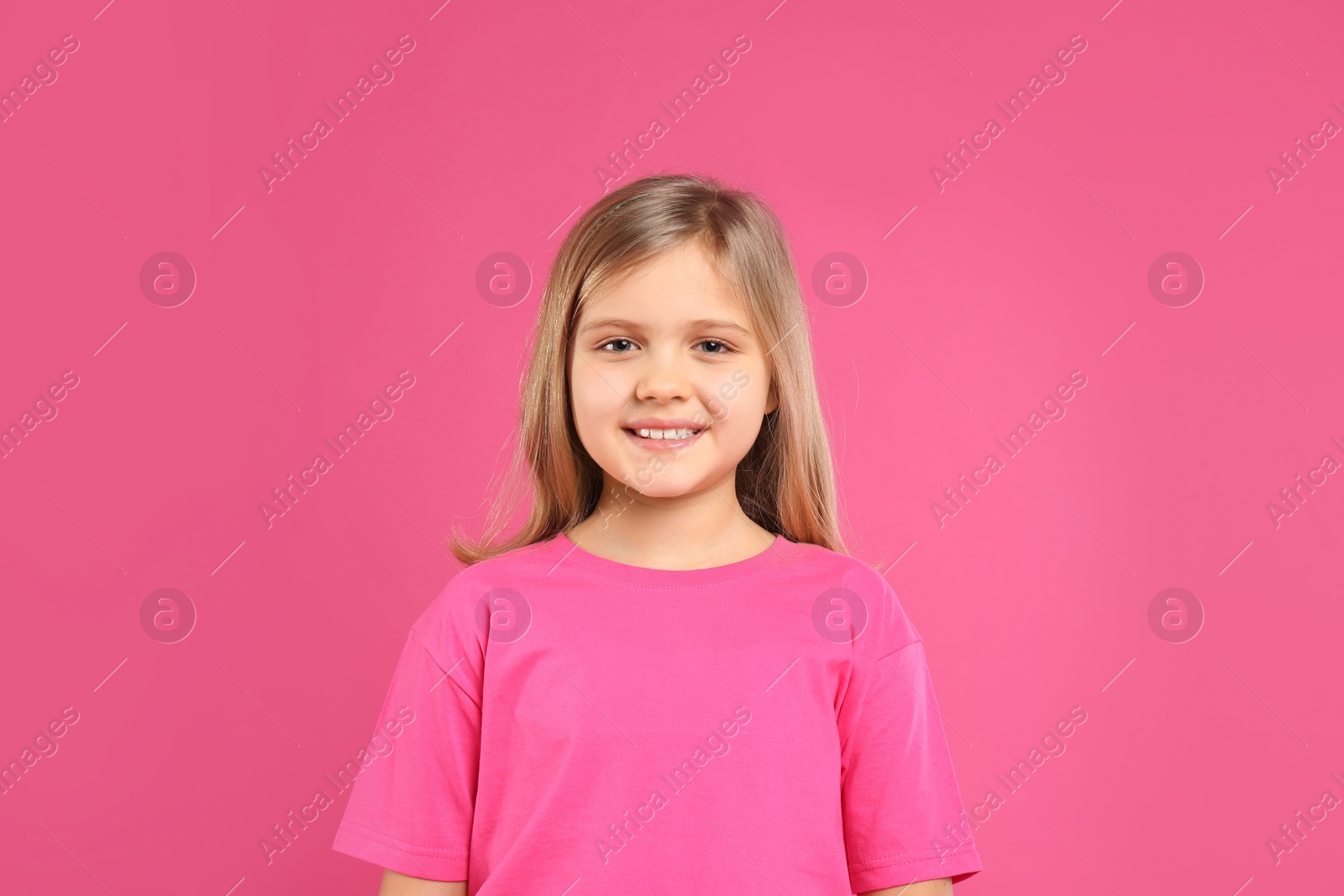 Photo of Cute little girl wearing casual outfit on pink background