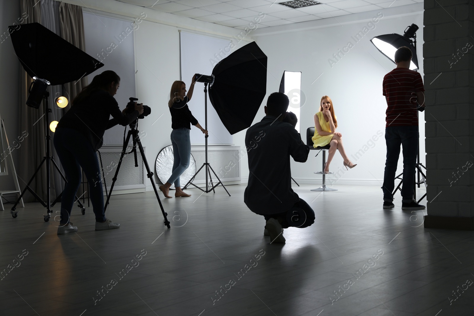 Photo of Photo studio with professional equipment and team of workers