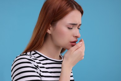 Photo of Woman coughing on light blue background, space for text. Cold symptoms