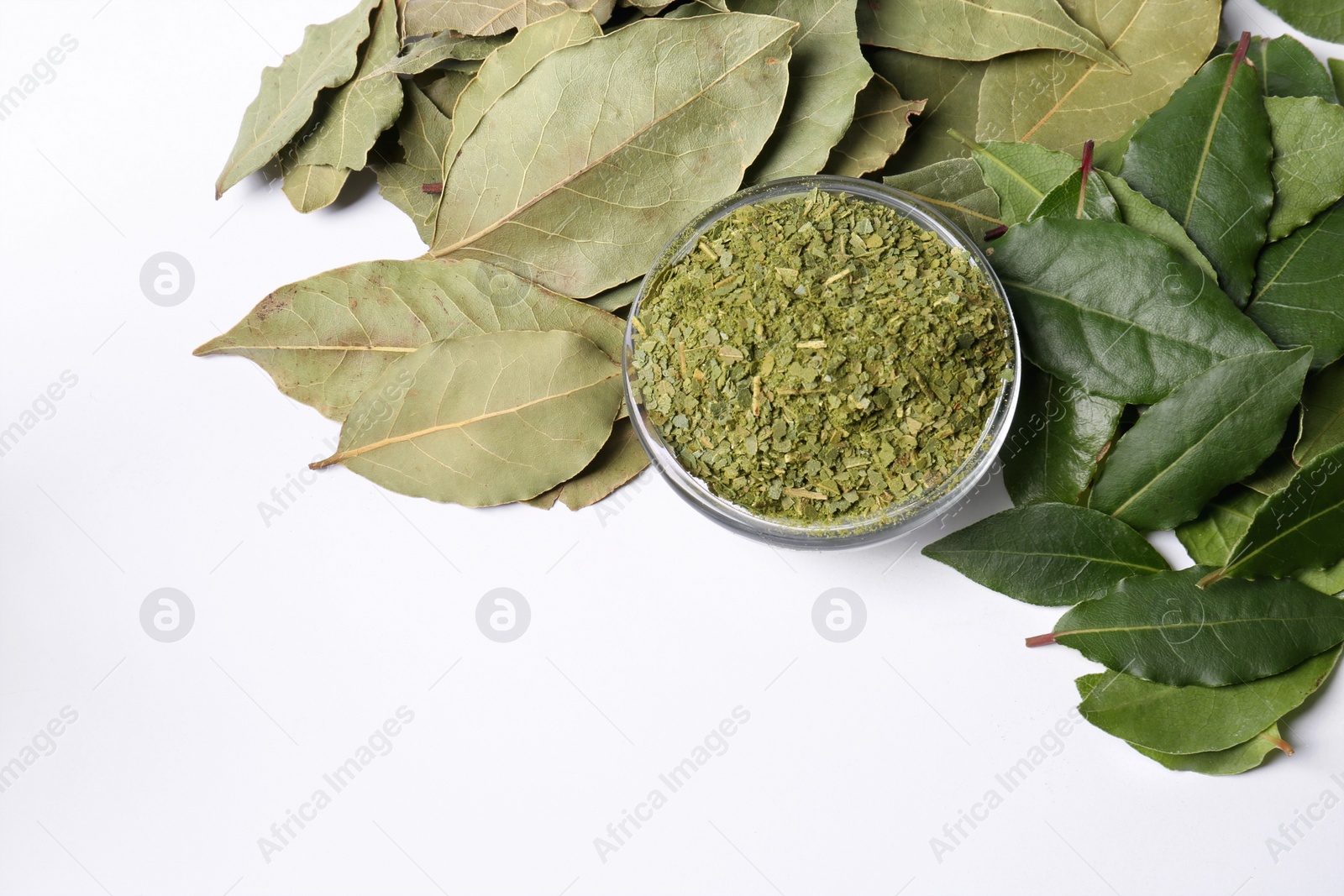 Photo of Fresh and ground bay leaves on white background, flat lay. Space for text