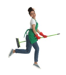 Photo of African American woman with green broom jumping on white background