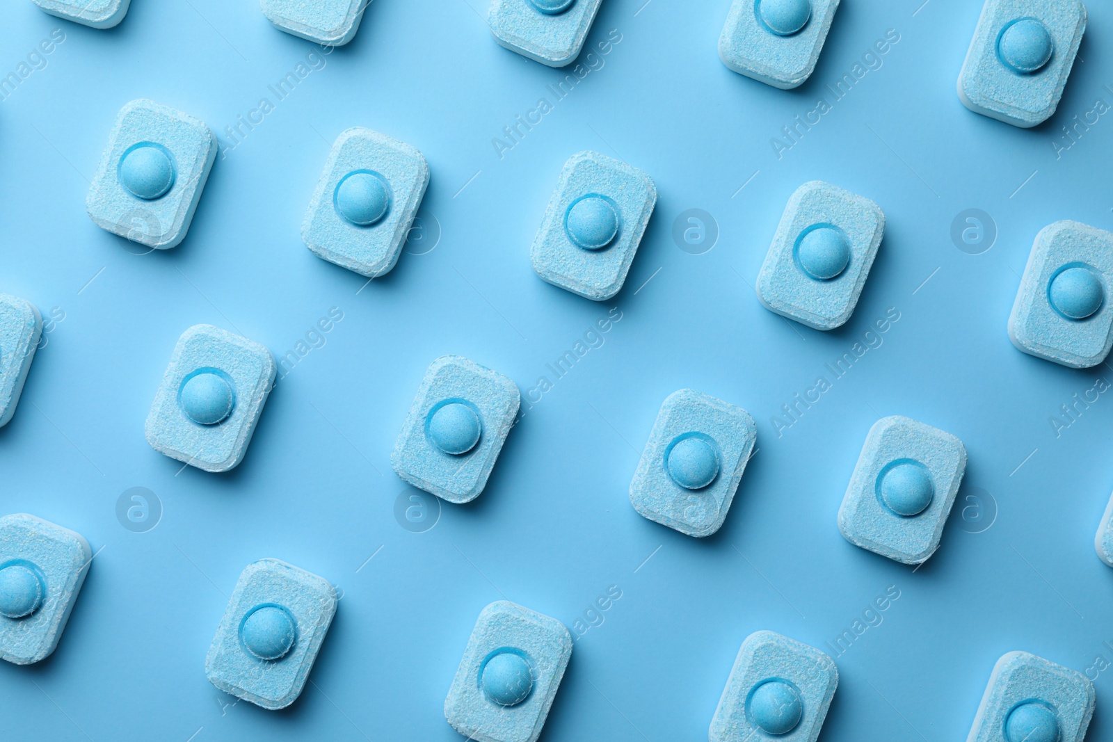 Photo of Water softener tablets on light blue background, flat lay