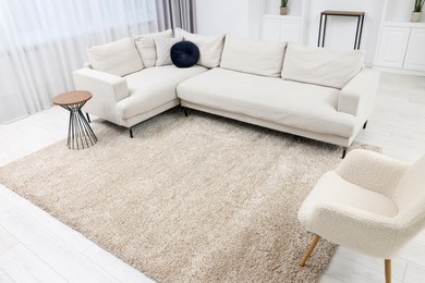 Photo of Fluffy carpet and stylish furniture on floor indoors