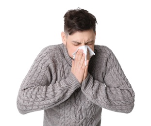 Man with tissue suffering from cold on white background