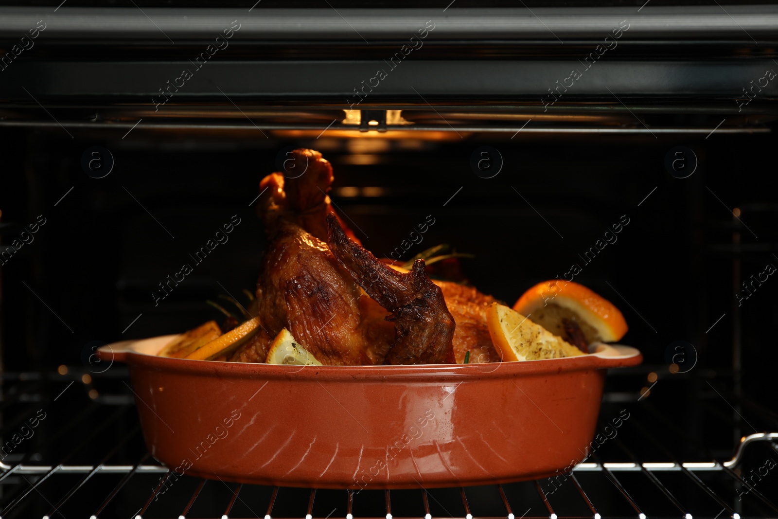 Photo of Chicken with orange slices baking in oven