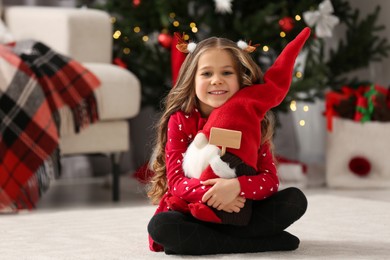 Portrait of happy little girl with Christmas toy at home