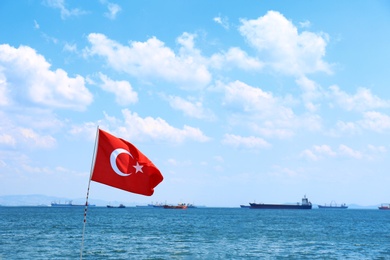 Photo of Turkish flag and seascape with ships on background