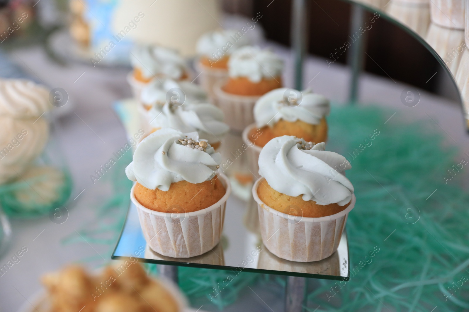 Photo of Delicious cupcakes with cream on dessert stand, closeup