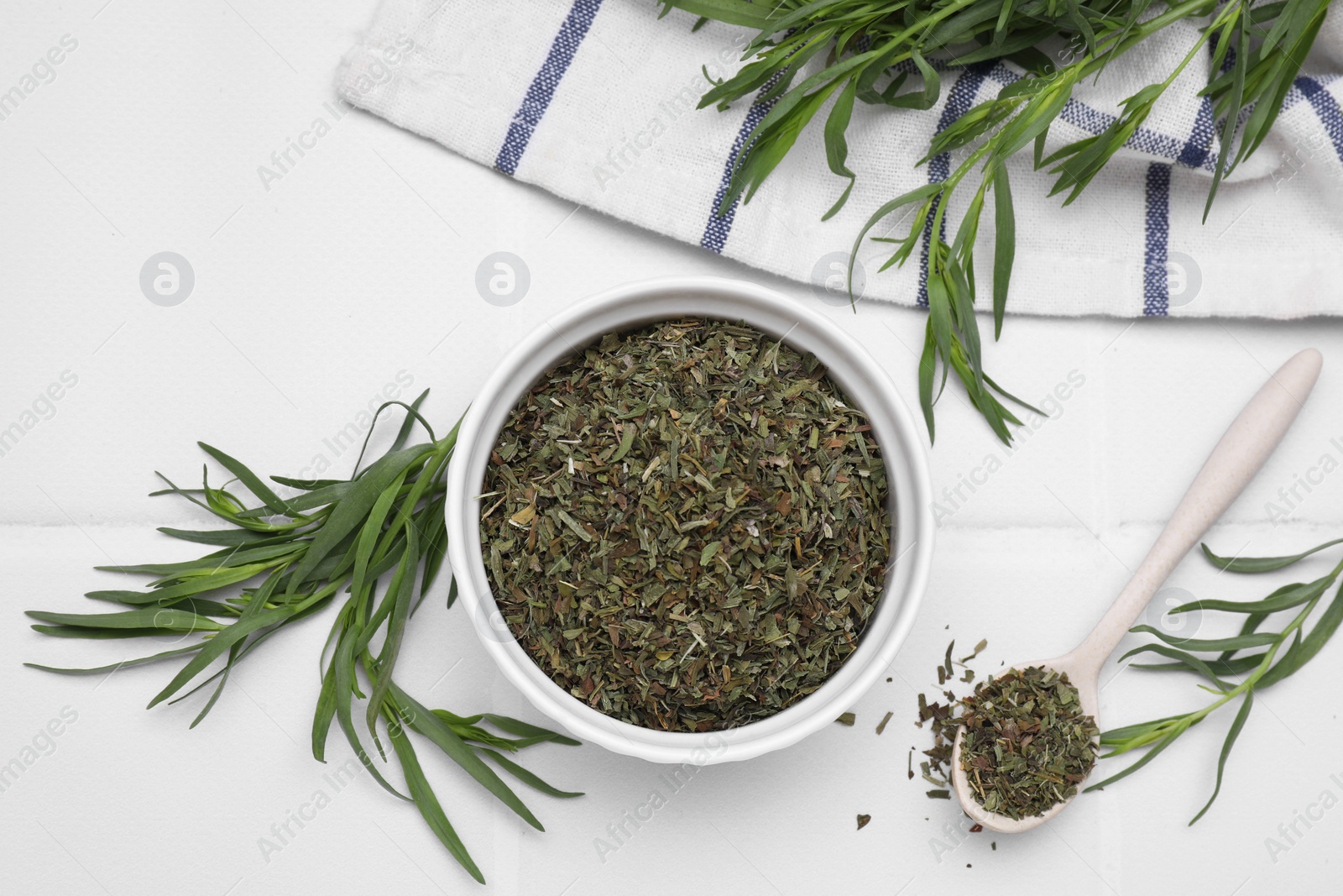 Photo of Dry and fresh tarragon on white tiled table, flat lay