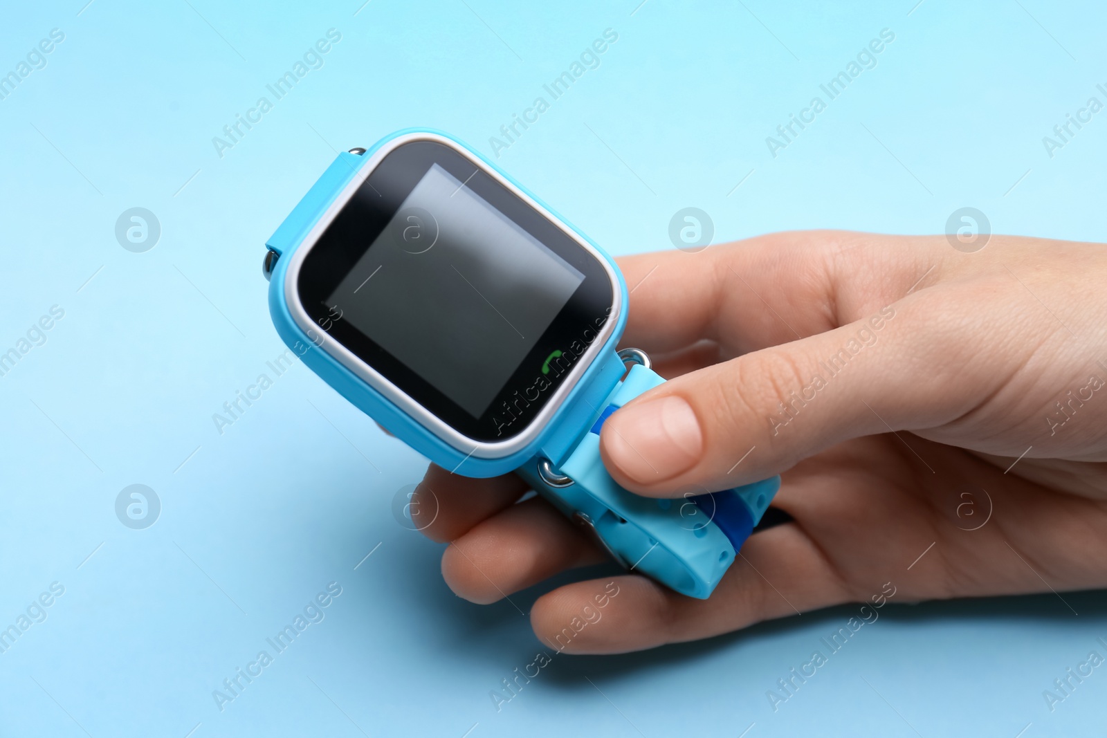 Photo of Boy with stylish smart watch on light blue background, closeup