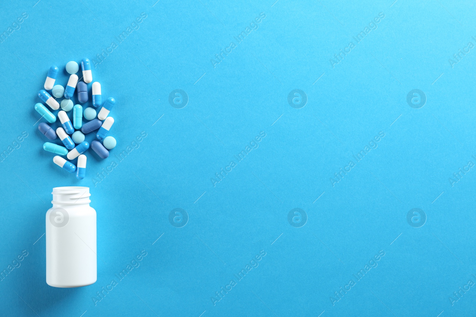 Photo of Flat lay composition with pills on light blue background. Space for text