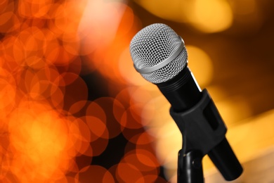 Microphone against festive lights, space for text. Musical equipment