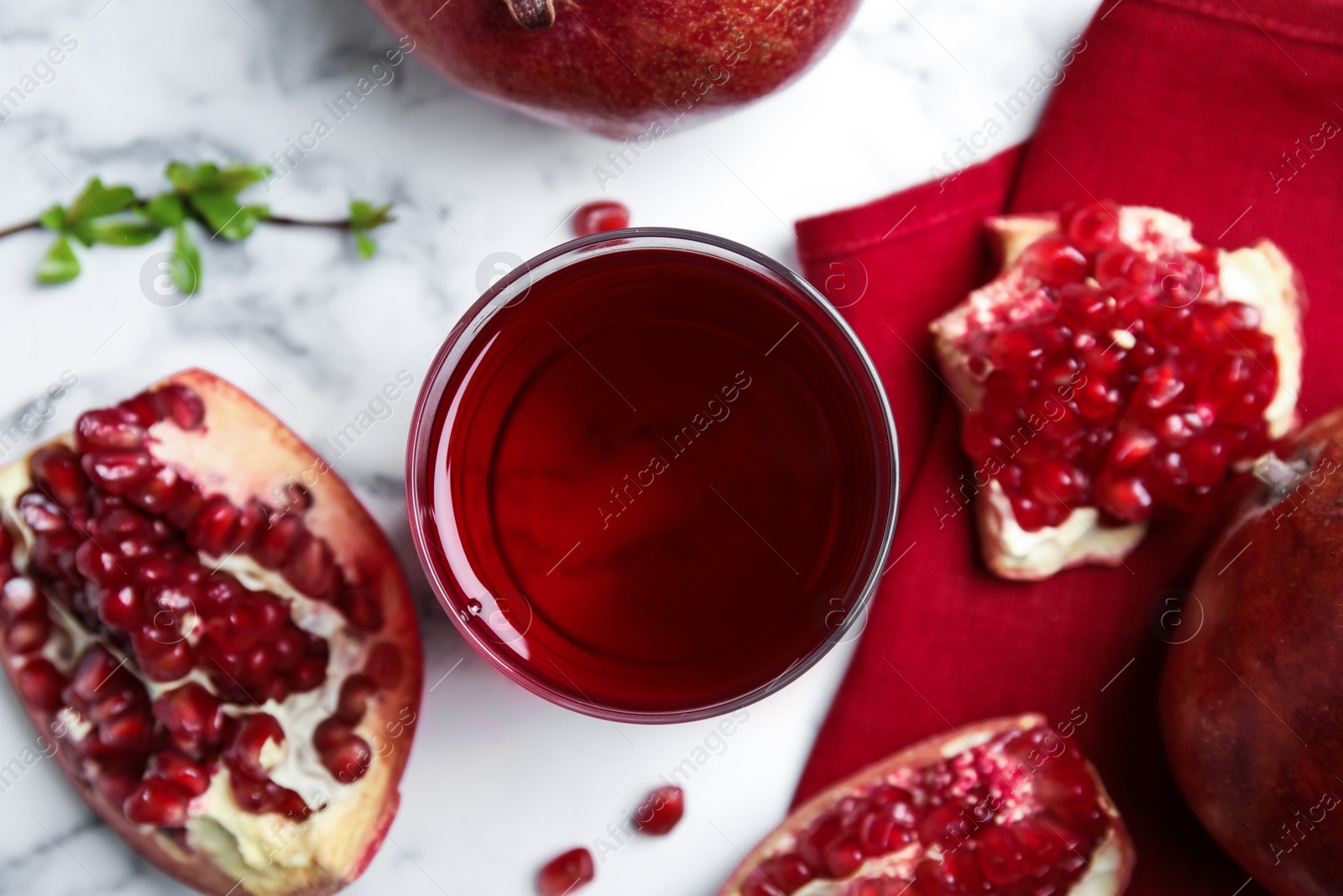 Photo of Pomegranate juice and fresh fruits on white marble table, flat lay