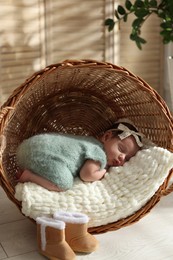 Adorable newborn baby sleeping in wicker basket at home