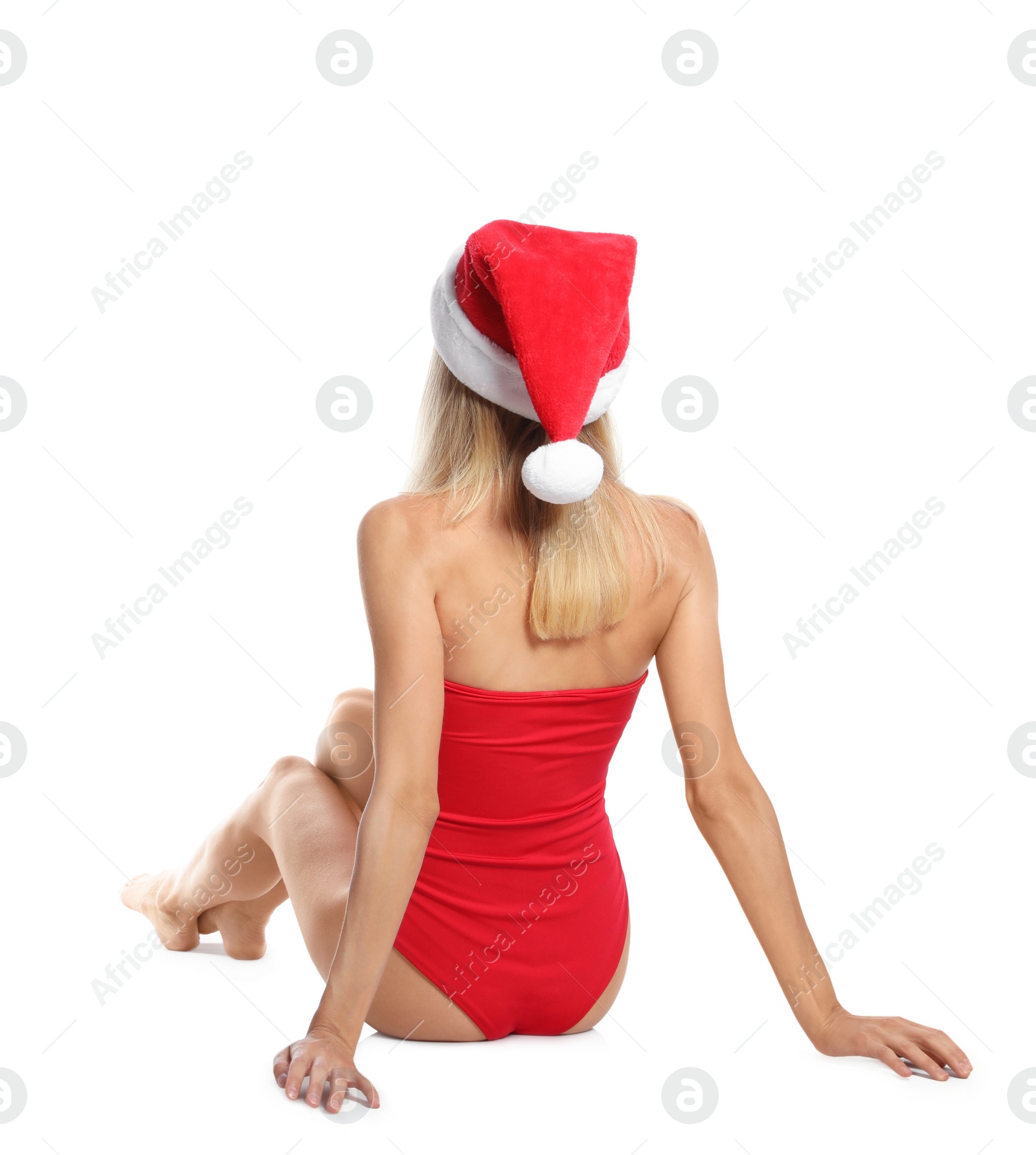 Photo of Young woman wearing Santa Claus hat on white background, back view. Christmas vacation