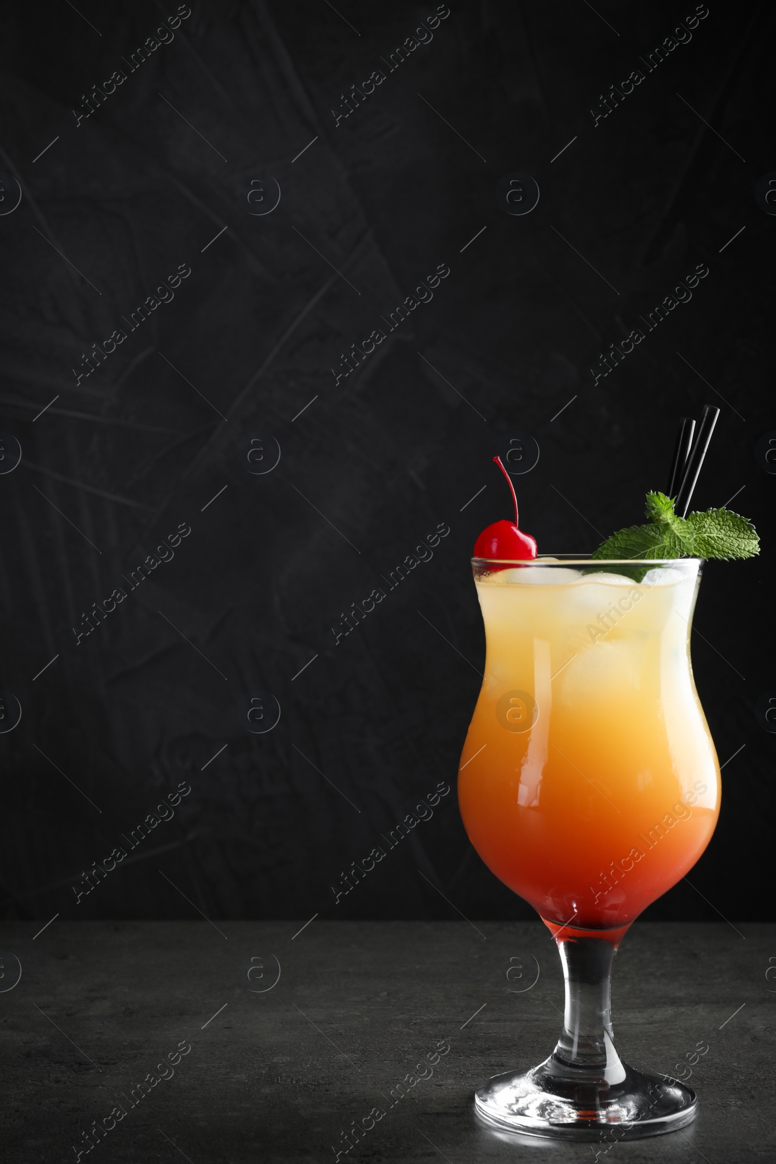 Photo of Just made appetizing cocktail Sex on the Beach, black background. Space for text