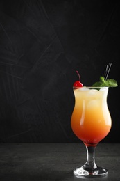 Photo of Just made appetizing cocktail Sex on the Beach, black background. Space for text