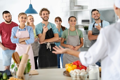 Photo of Group of people and female chef at cooking classes