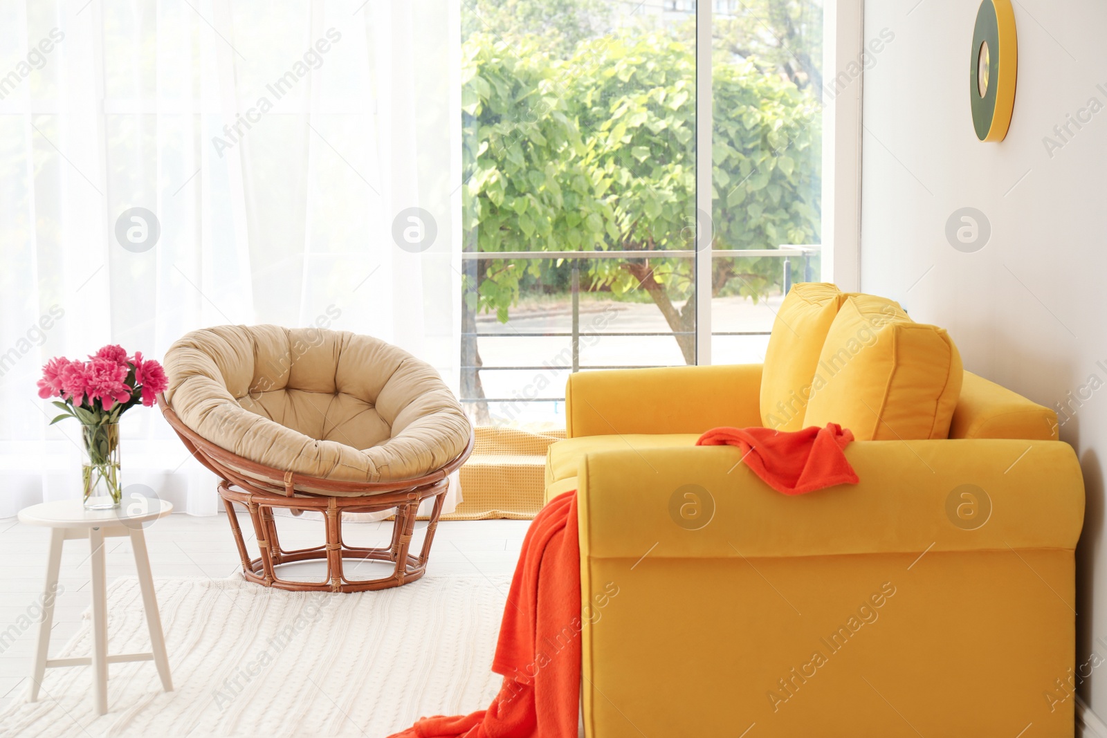 Photo of Elegant living room interior with comfortable sofa and papasan chair