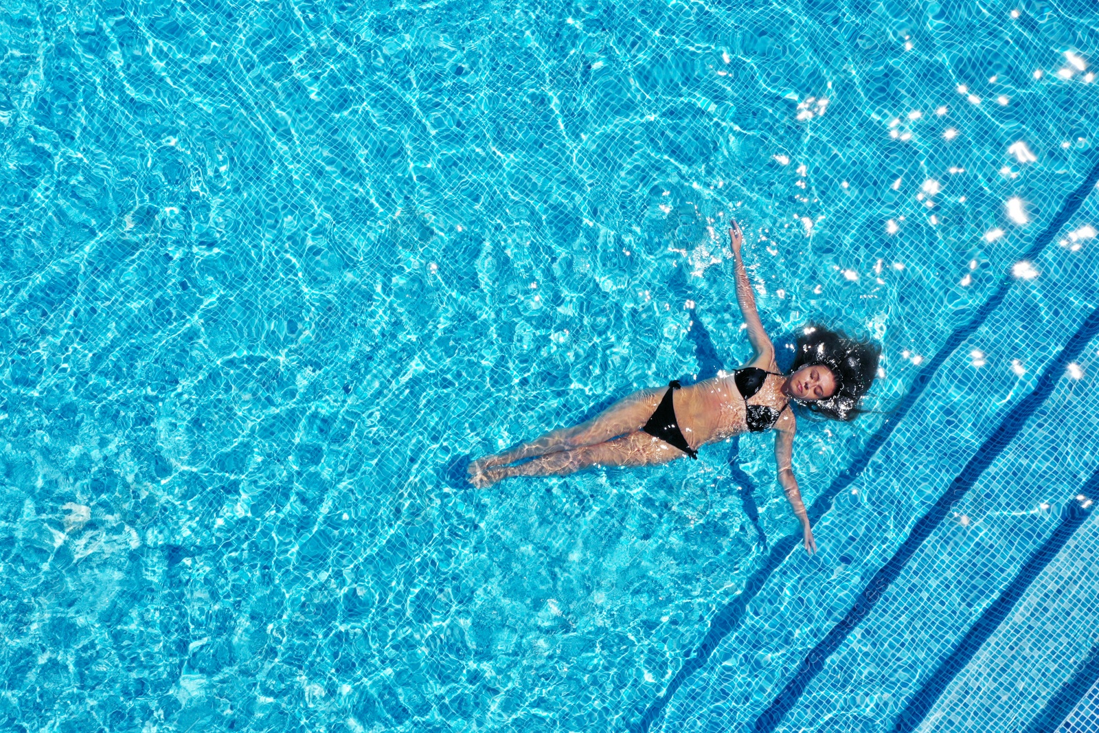 Image of Beautiful young woman swimming in pool, top view. Space for text