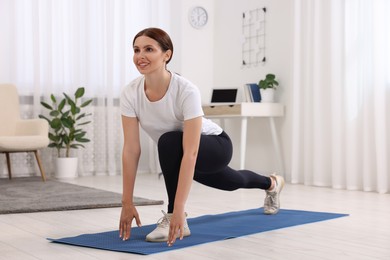 Photo of Morning routine. Happy woman doing stretching exercise at home